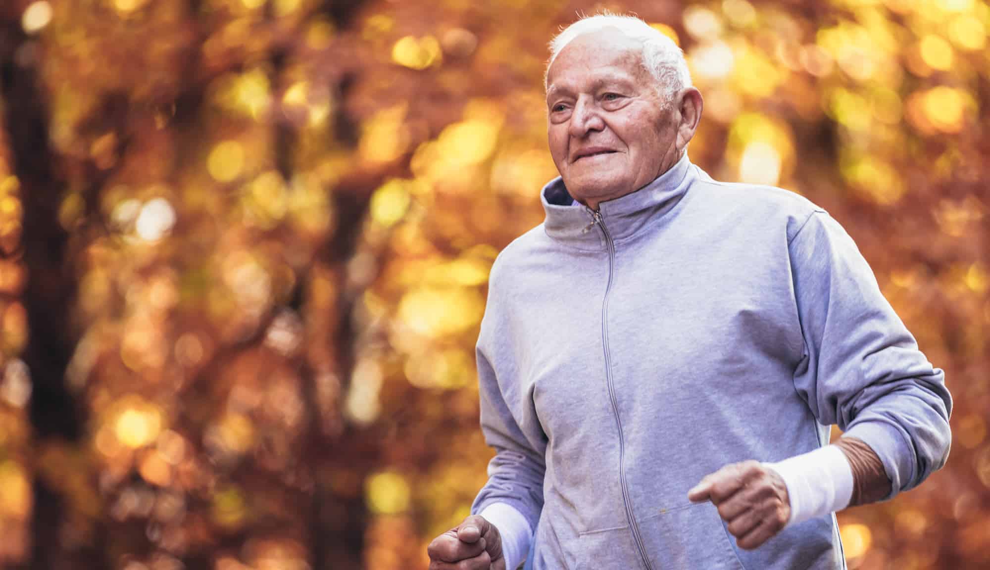 An older man jogging in the autumn.